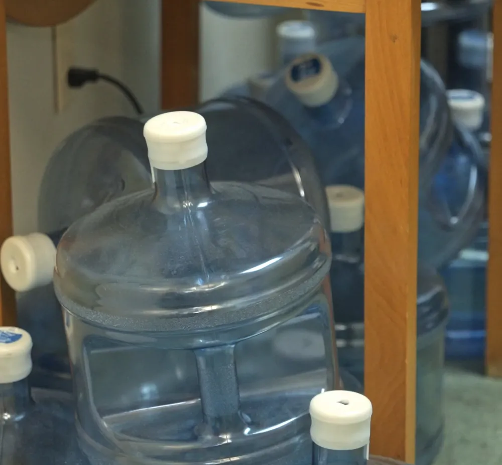 Stacked 5-gallon water bottles waiting to be lifted and stored